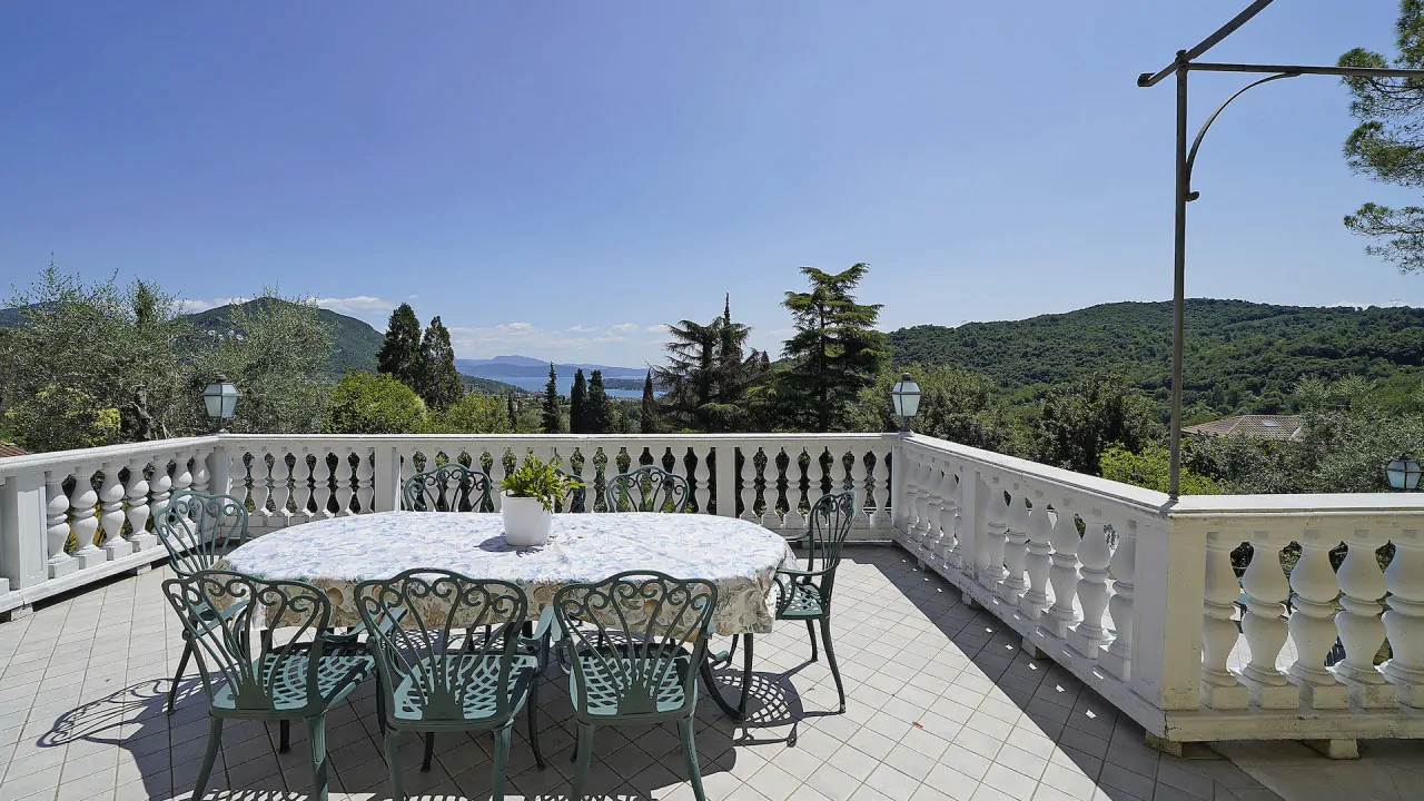 Terrasse mit rundem Tisch und Schmiedeeisenstühlen