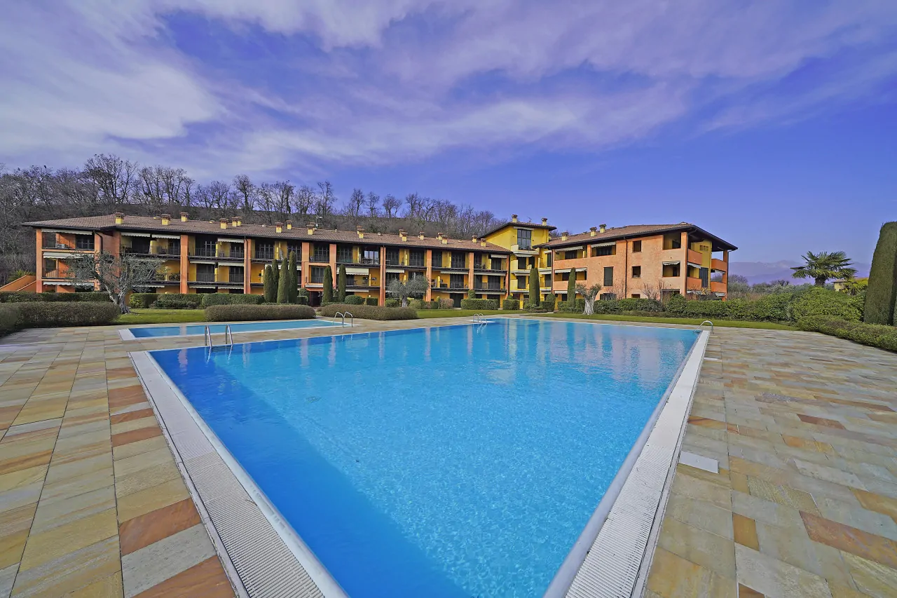 Piscina rettangolare in residence con edificio sullo sfondo