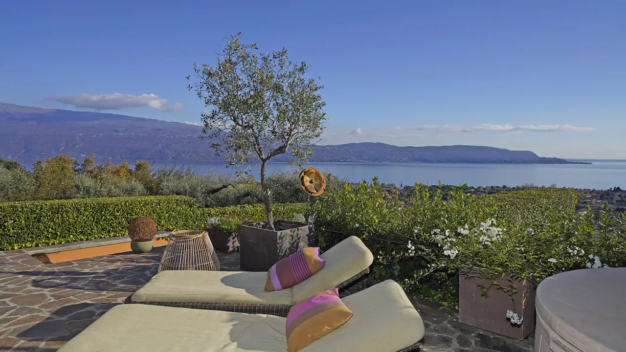 Terrazza con lettini e vista sul lago e montagne
