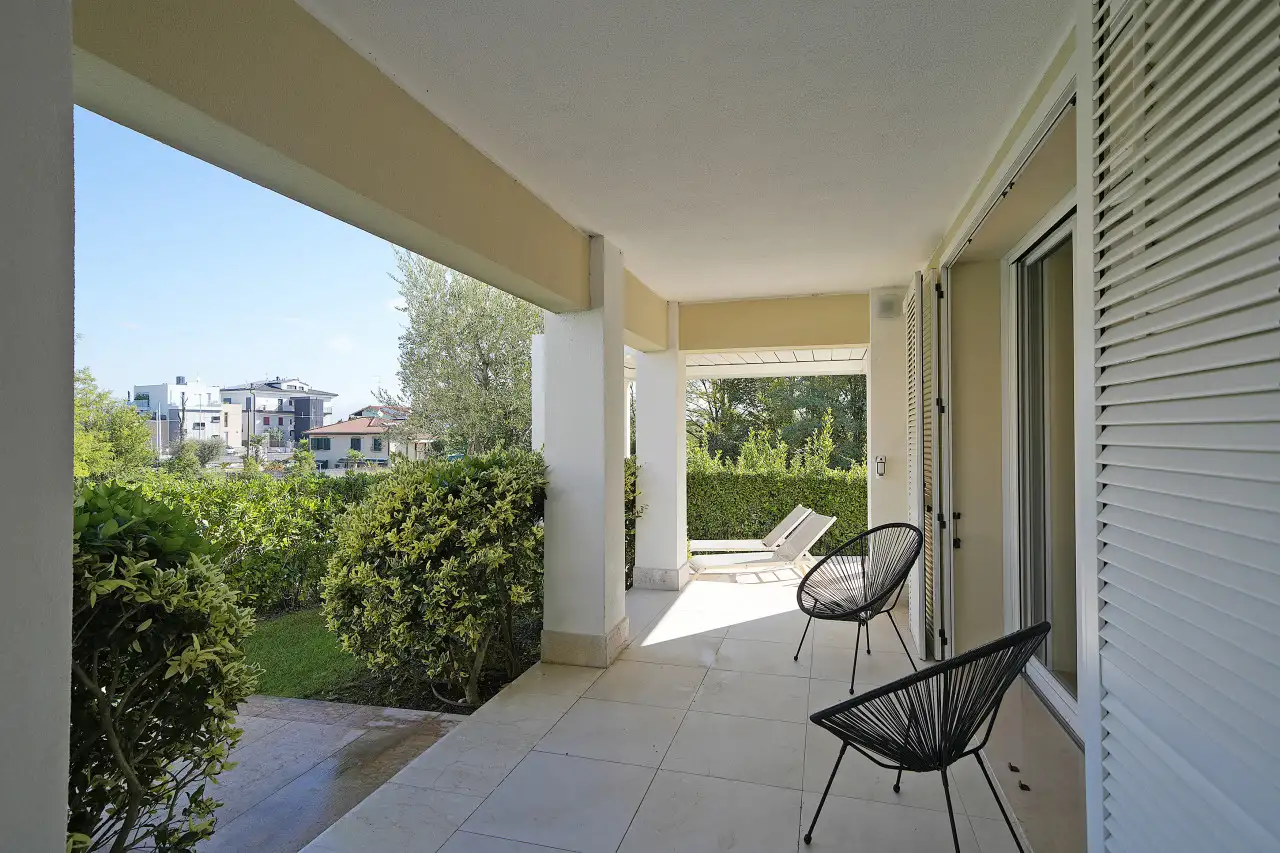 Terrazza coperta con sedie e lettini prendisole