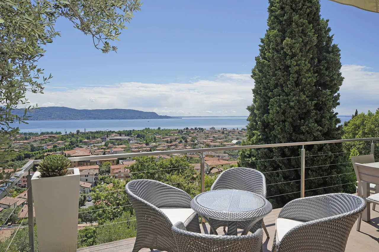 Terrasse mit Korbtisch und Stühlen und Seeblick