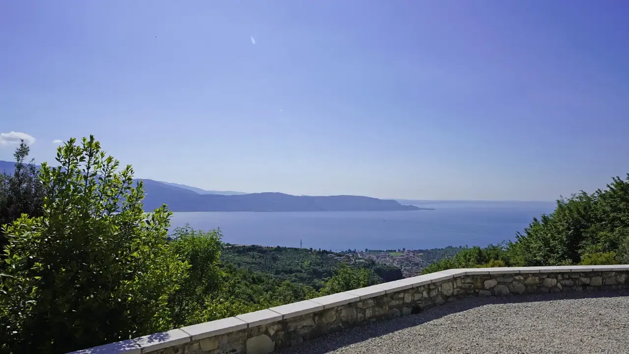 Panoramic view of Lake Garda from terrace with stone wall