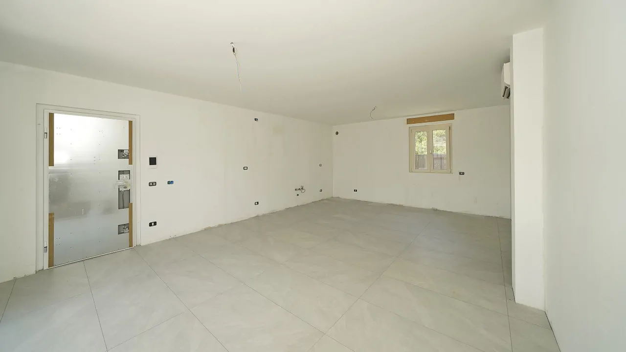 Soggiorno vuoto con porta in vetro e finestra