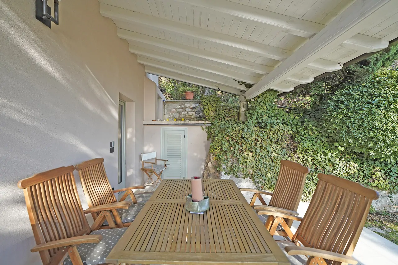 Covered terrace with wooden table and chairs