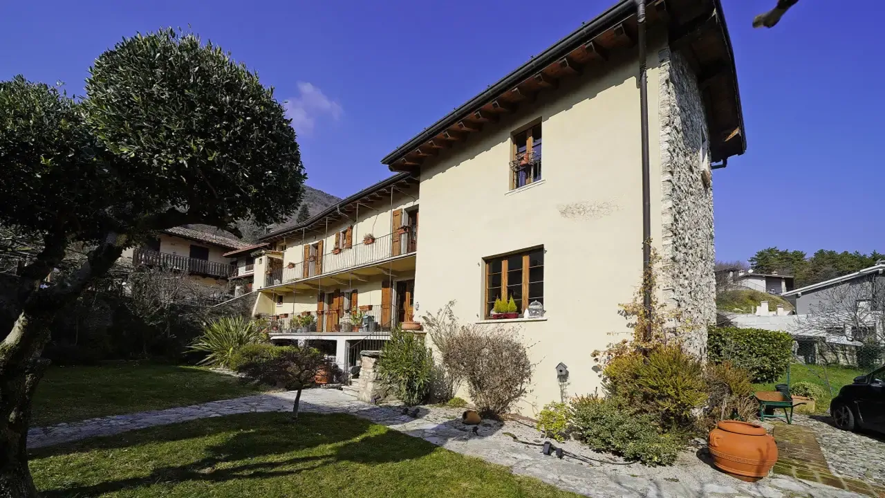 Fassade des historischen Hauses mit Garten und geschnittenen Bäumen