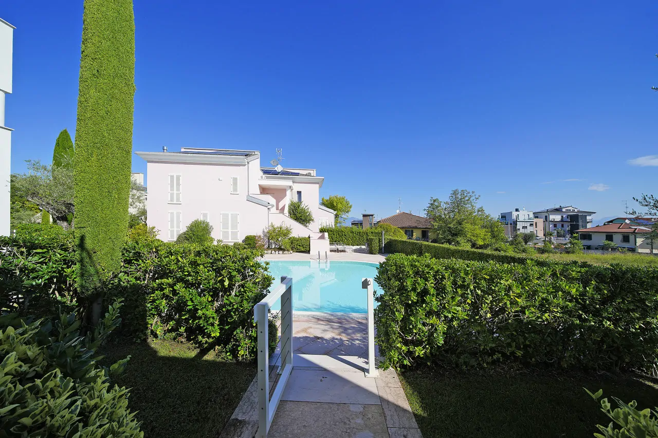 Piscina con ingresso e siepi verdi intorno