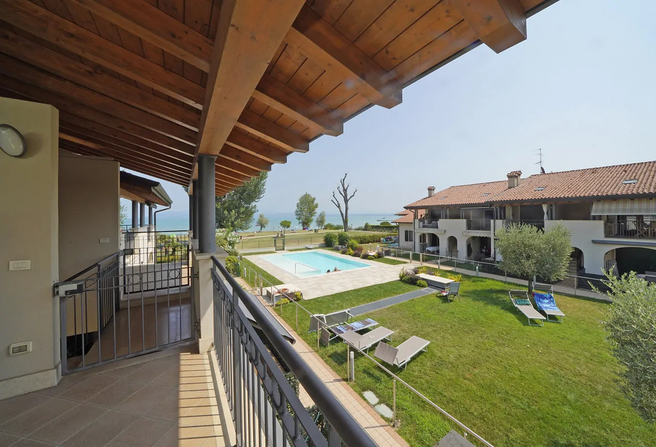 Überdachte Terrasse mit Blick auf Pool und Garten