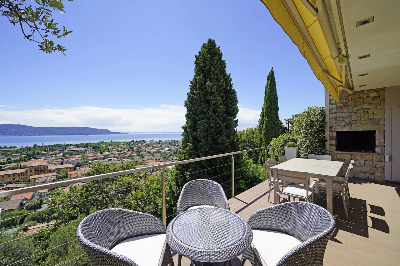 Terrasse mit Tisch und Stühlen mit Blick auf See und Landschaft