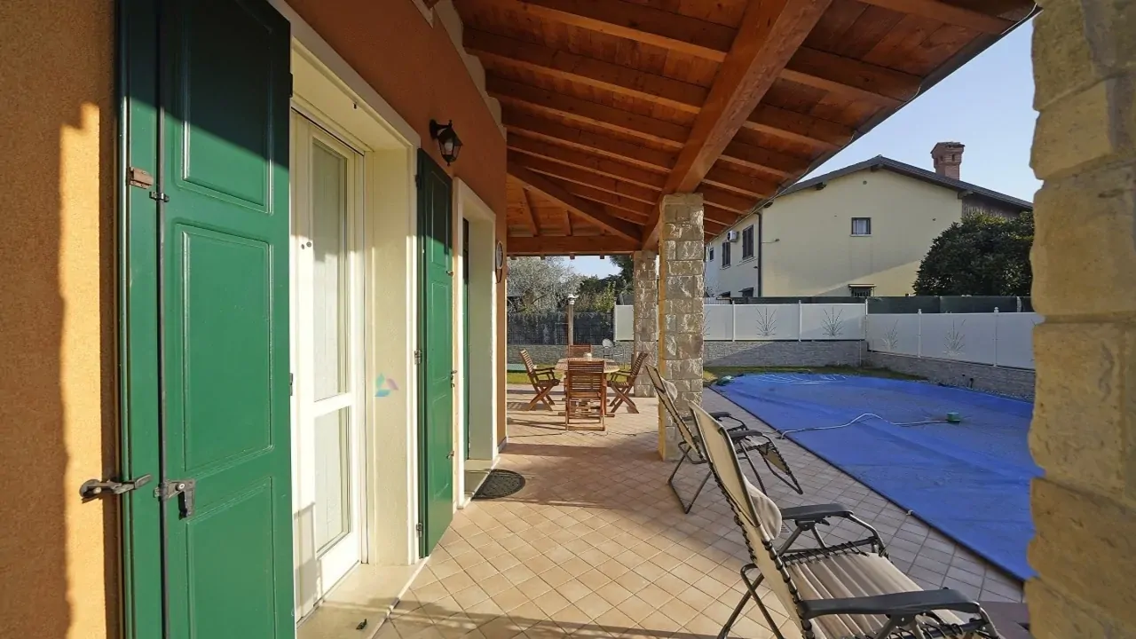Veranda mit abgedecktem Pool und Gartenmöbeln