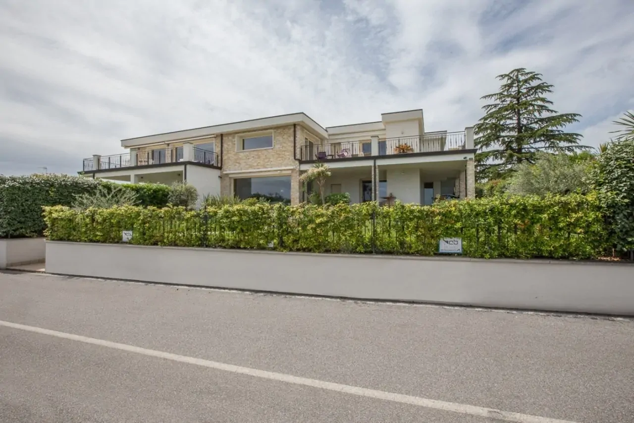 Exterior facade of residential building with hedges and balconies