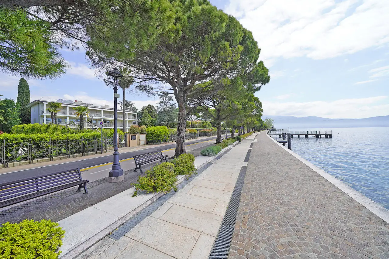 Lungolago con panchine, alberi e vista sul lago