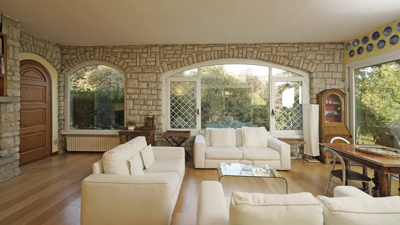 Wohnzimmer mit weißen Sofas und großen Bogenfenstern