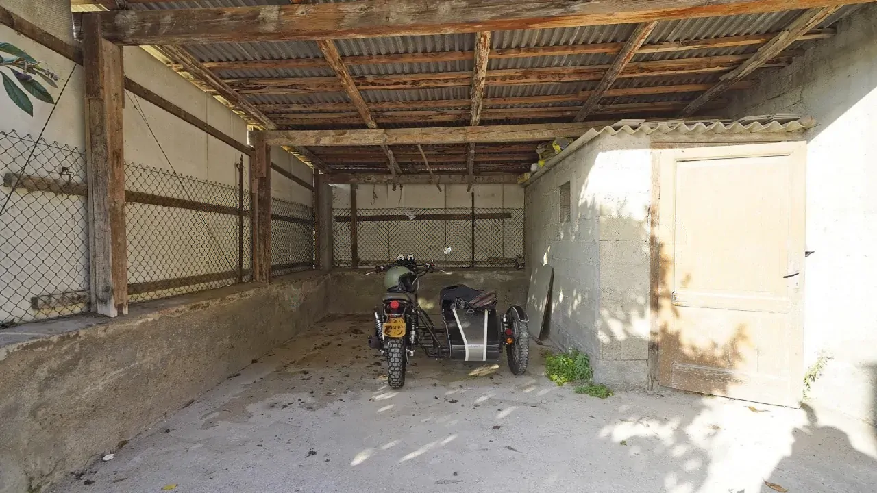 Spazio esterno coperto con moto e rimessa