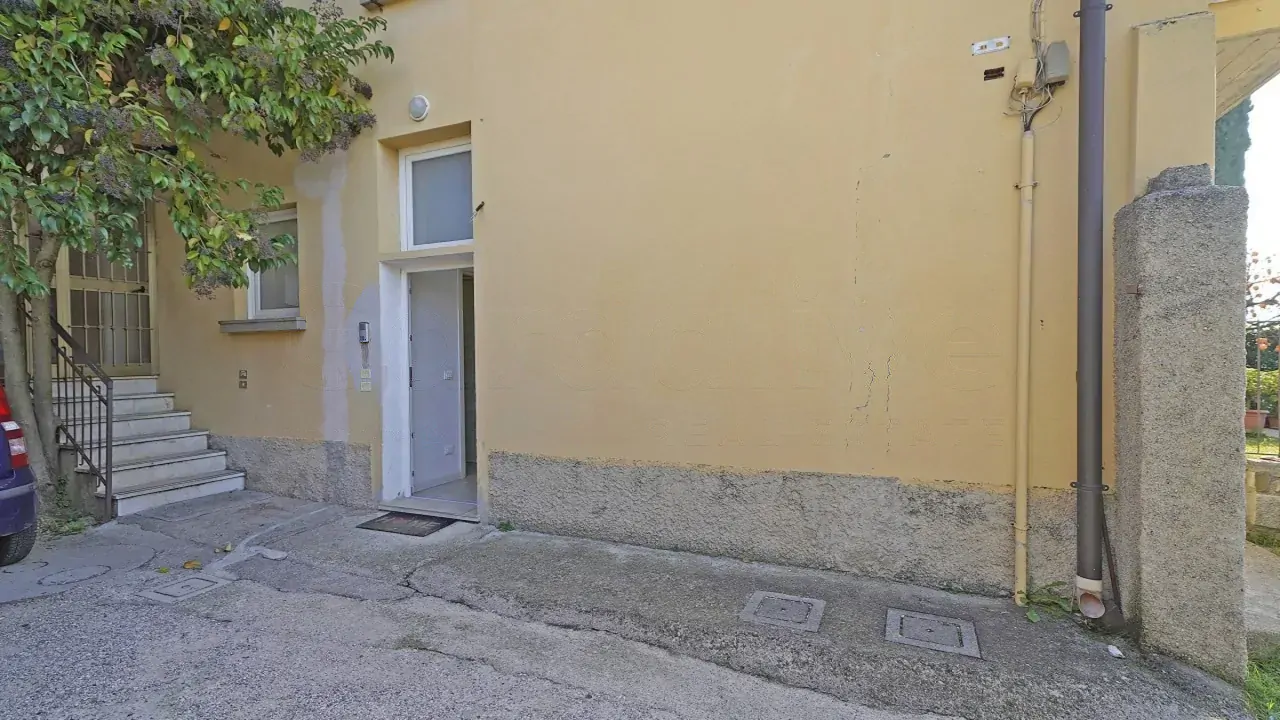 Ingresso con porta bianca su muro giallo esterno