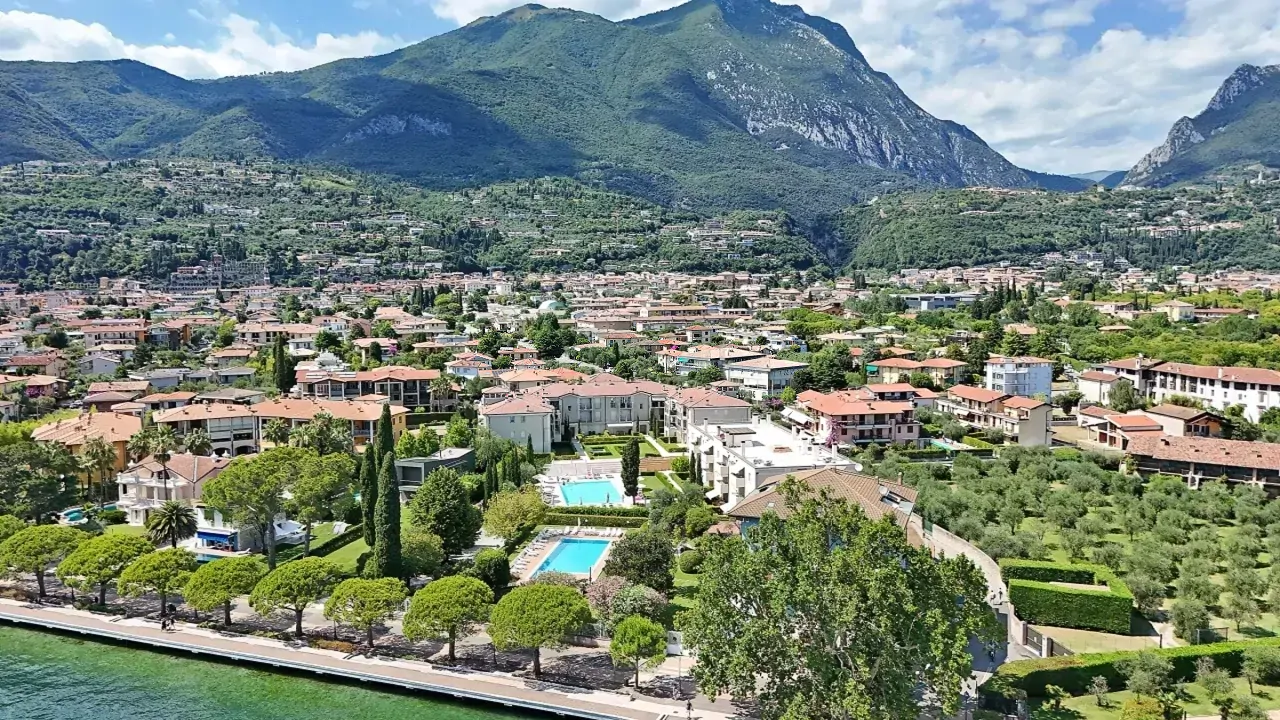 Luftaufnahme der Uferpromenade mit Pool und Bergen im Hintergrund in Toscolano Maderno