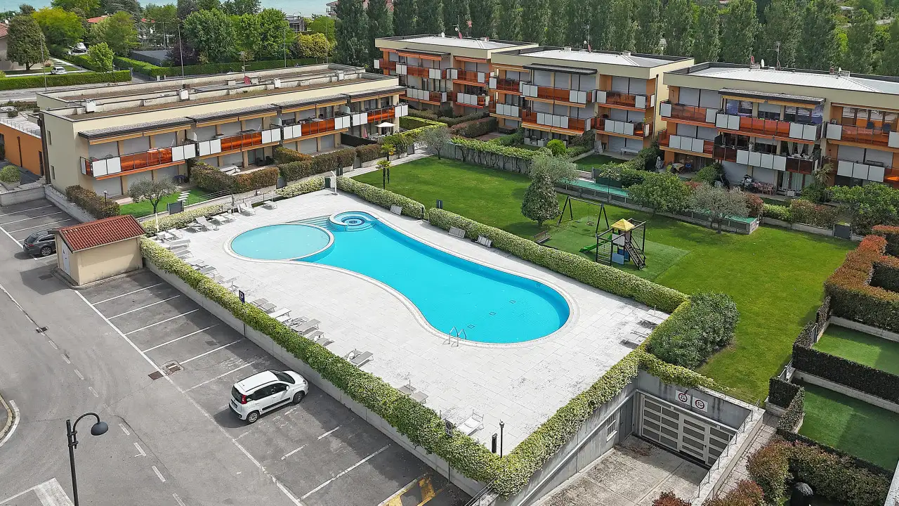 Vista aerea della piscina condominiale e giardino con area giochi
