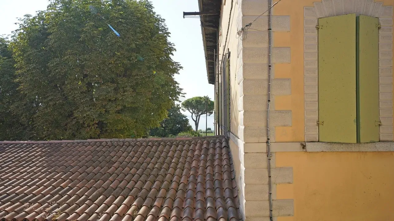 Außenansicht mit Ziegeldach und geschlossenem grünem Fensterladen