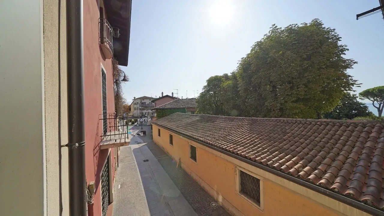 Blick auf Straße und Dach mit Bäumen im Hintergrund