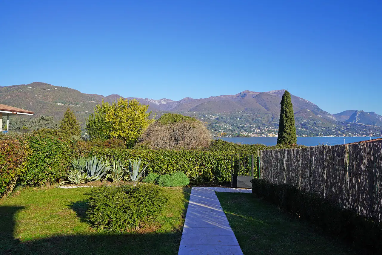 Garden with lawn, hedges and view of lake and mountains