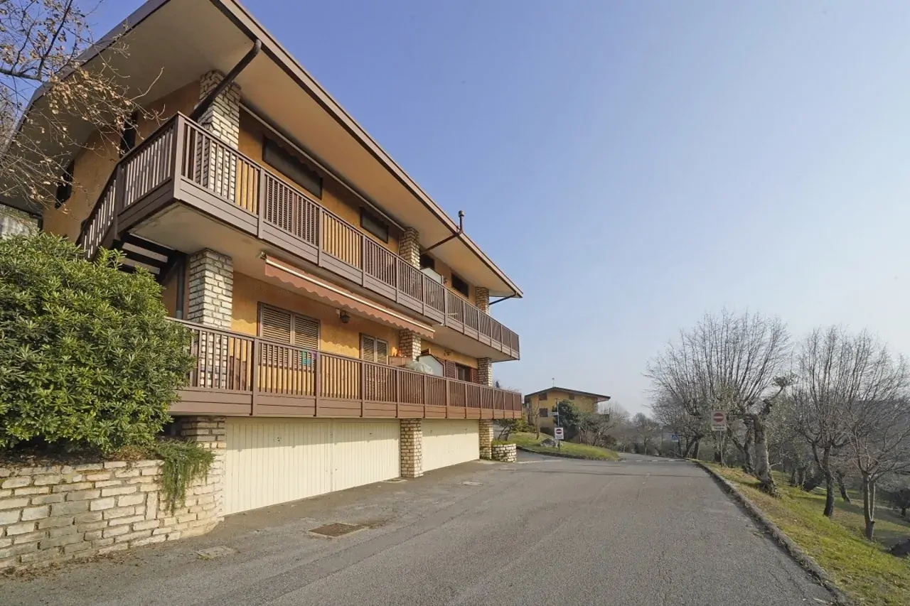 Fassade eines Wohngebäudes mit Balkonen und angrenzender Straße