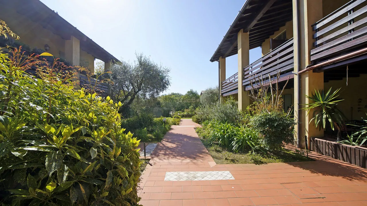 Outdoor path with plants and wooden balconies in residence at Soiano del Lago