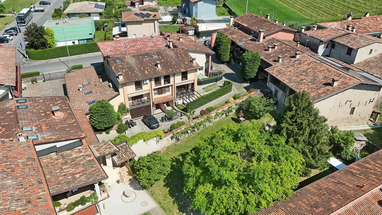 Veduta aerea della villetta a schiera con giardino privato e tetti circostanti