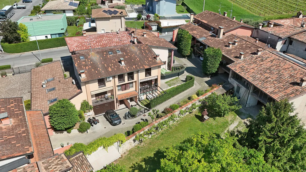 Vista aerea della villetta a schiera con giardino privato e tetti circostanti