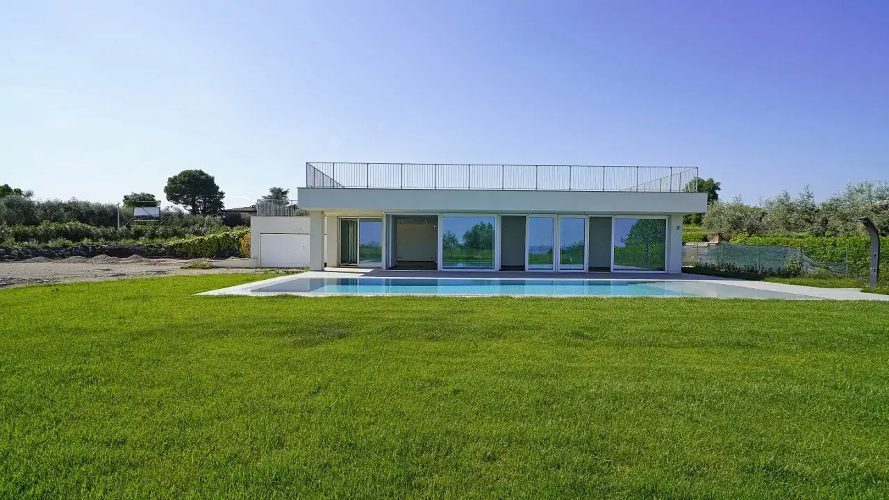 Moderne Villa mit Pool und grünem Rasen