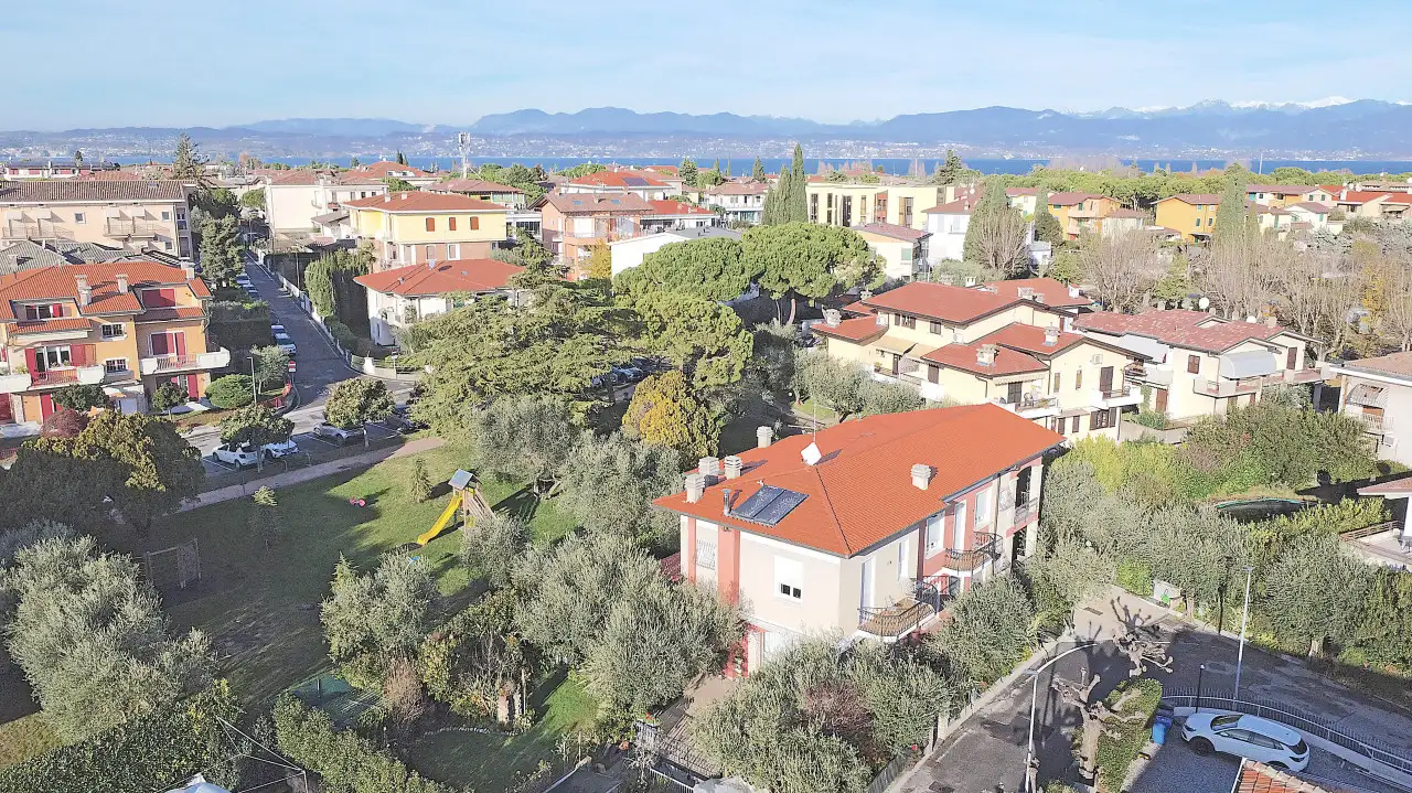 Aerial view of the villa with garden and surrounding houses in Sirmione