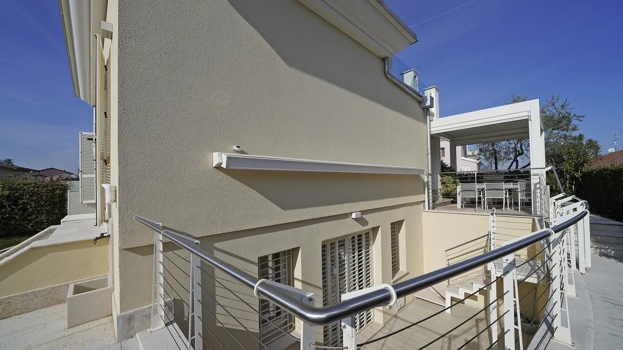 Esterno della villetta con ringhiera in metallo e terrazza coperta