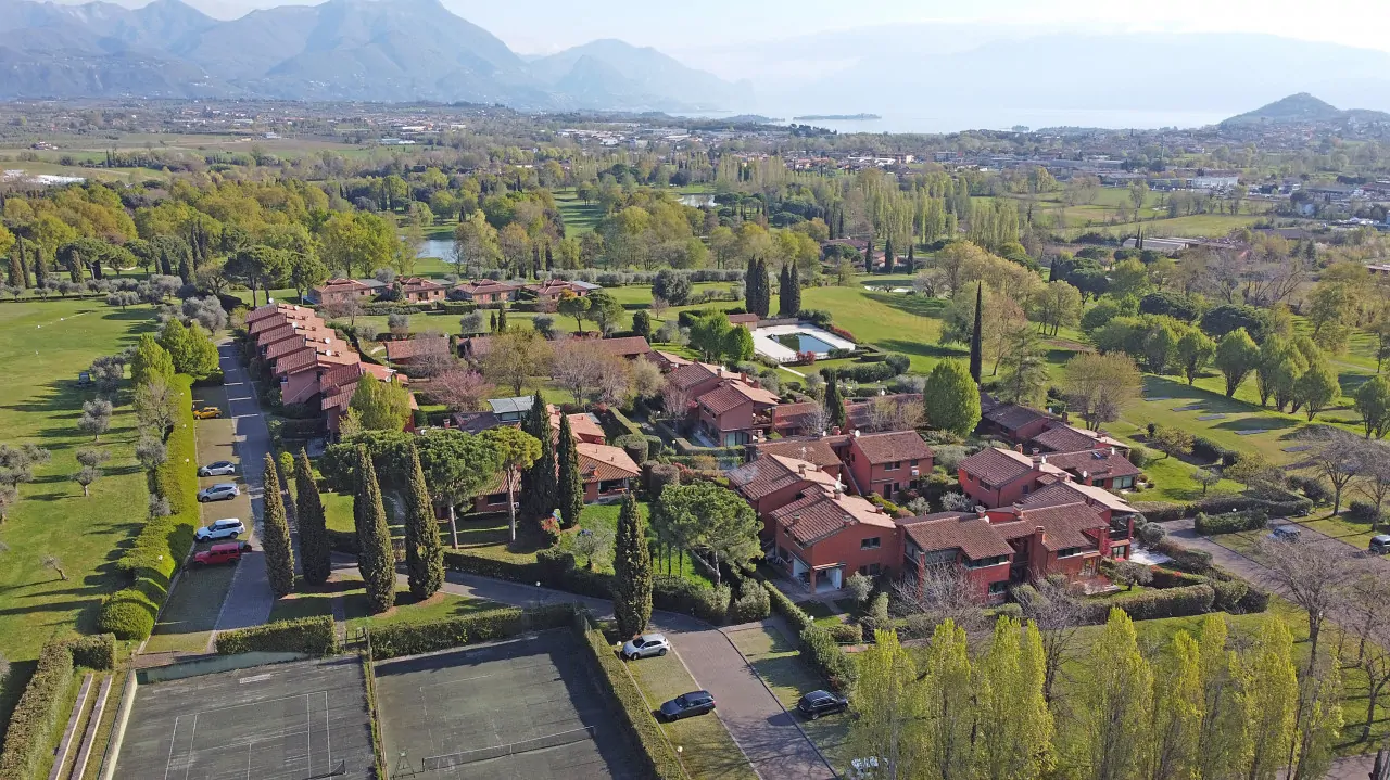 Veduta aerea del complesso residenziale con aree verdi e campi da tennis