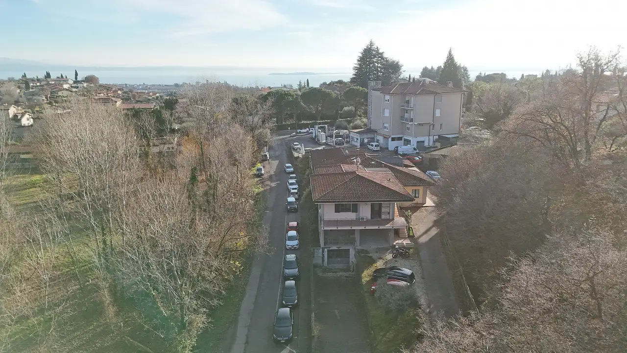 Aerial view of residential building and street with parked cars in Soiano del Lago