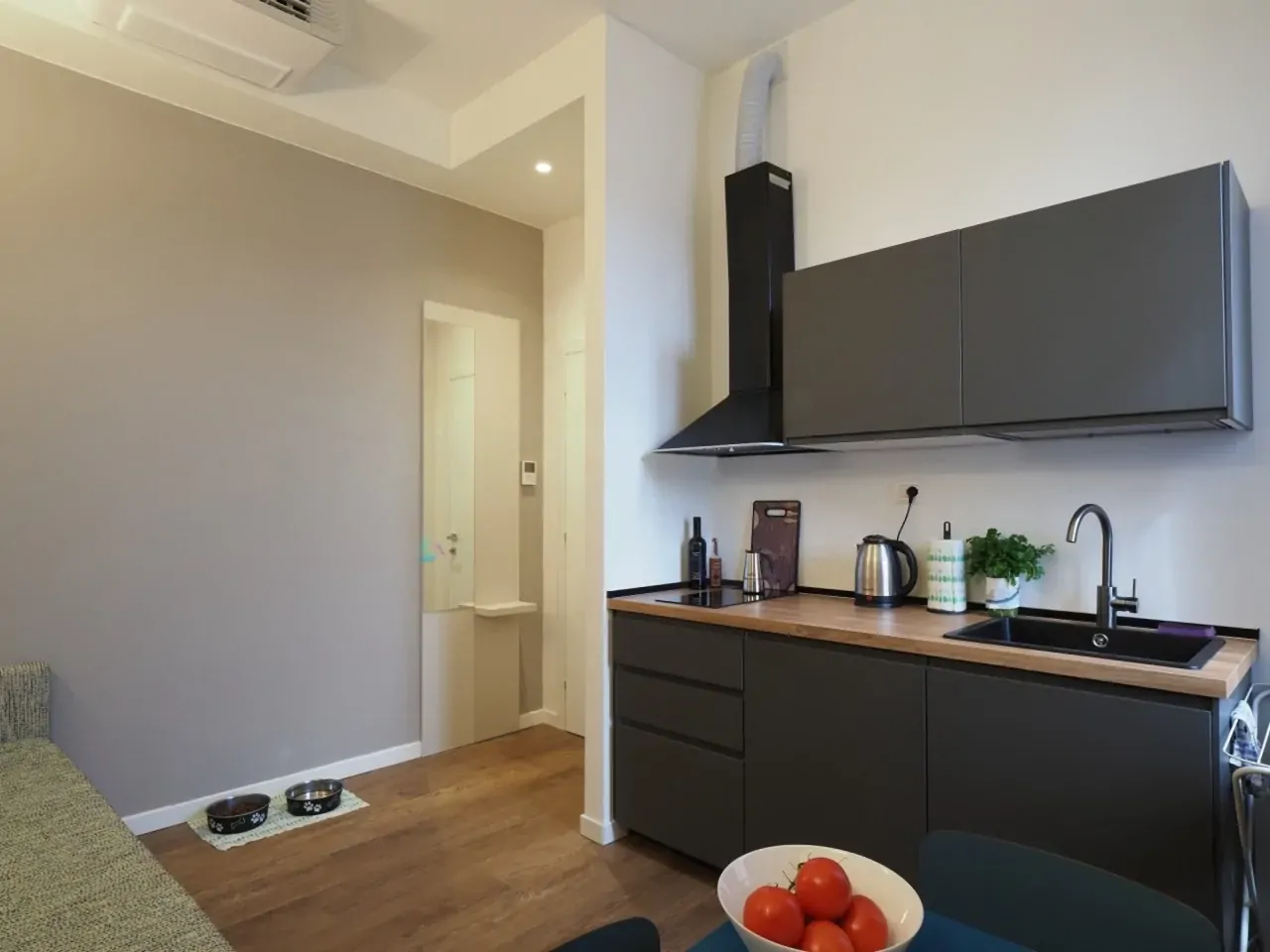 Cucina moderna con mobili scuri e piano in legno