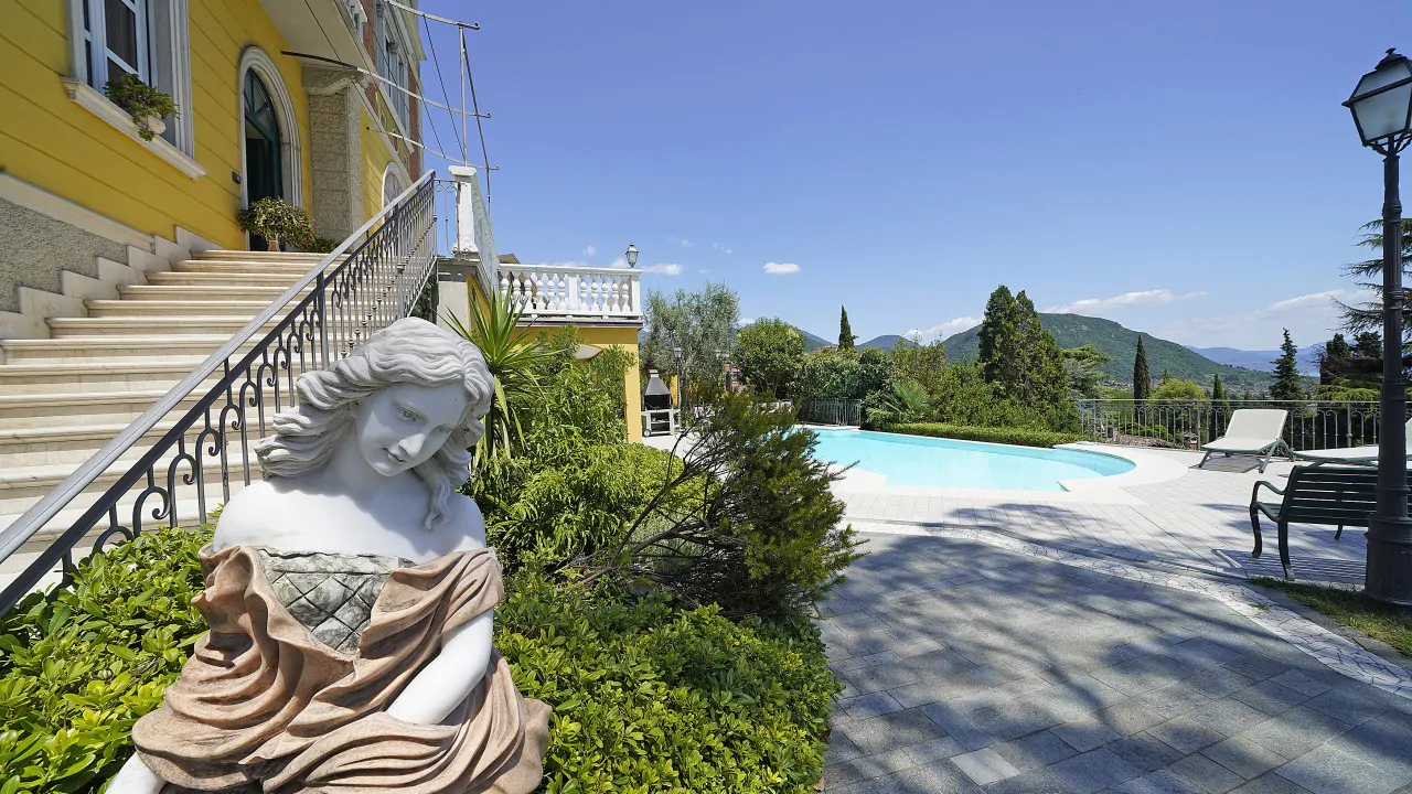 Statue im Garten nahe Pool und gelbem Haus