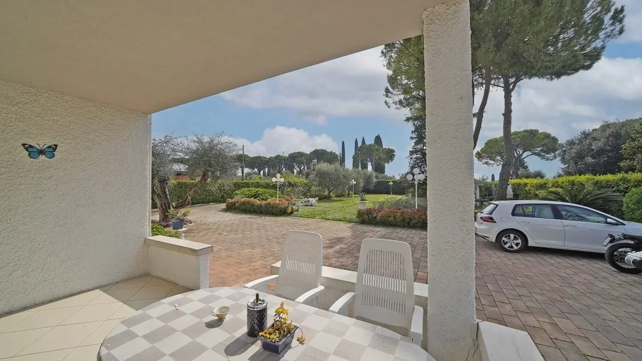 Portico con tavolo e sedie affacciato sul giardino e parcheggio