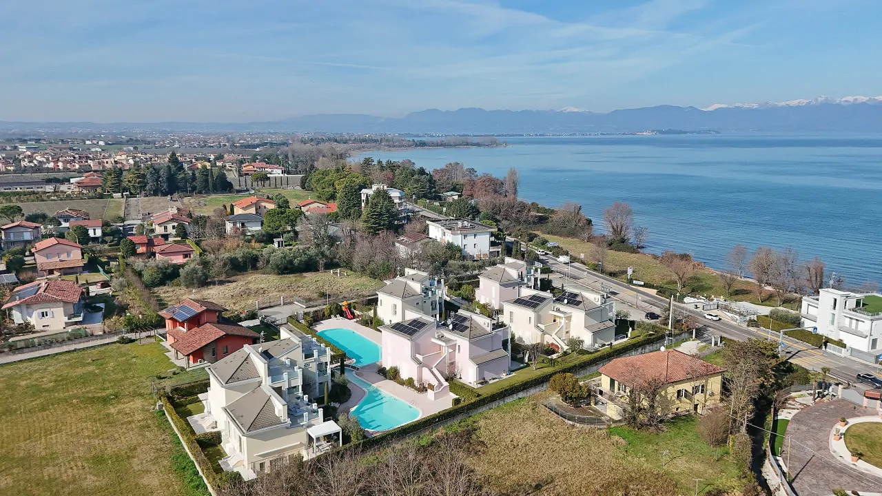 Vista aerea di villetta con piscina e lago sullo sfondo a Peschiera del Garda