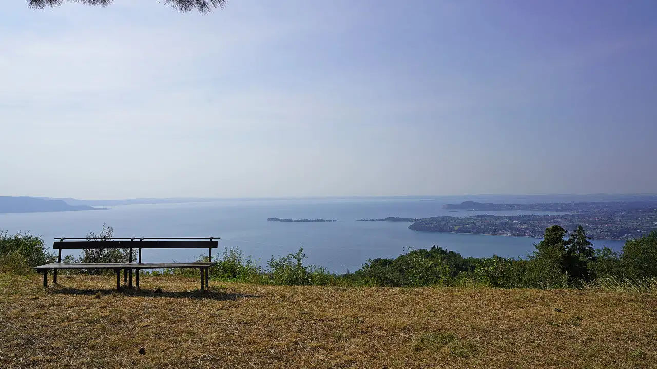 Bench on grass with view of lake and island