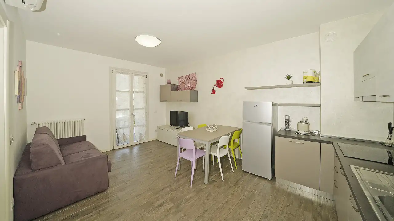 Living room with sofa, table, and open kitchen