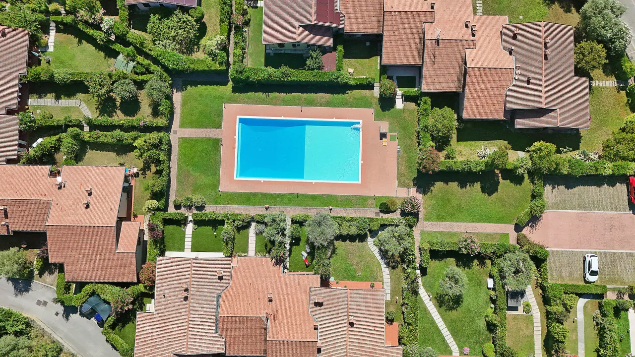 Piscina rettangolare in residence con prato e vialetti