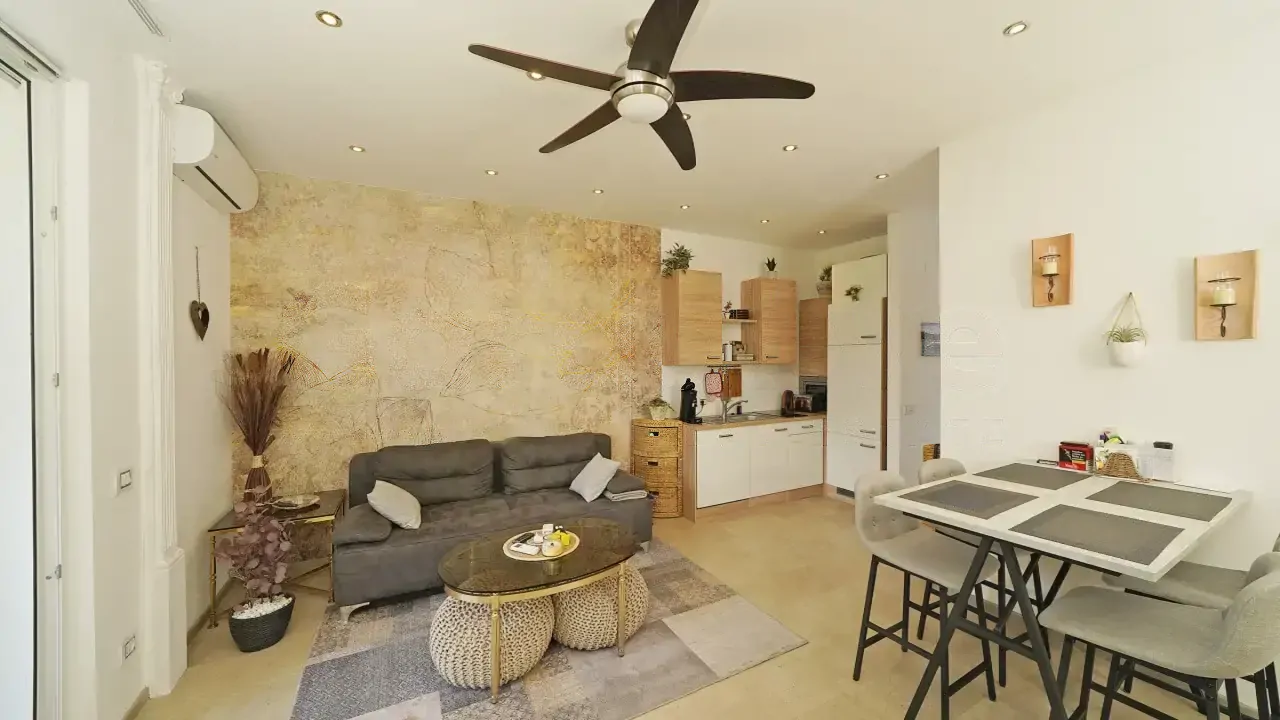 Wohnzimmer mit grauem Sofa, Couchtisch und Essbereich mit Tisch und Stühlen