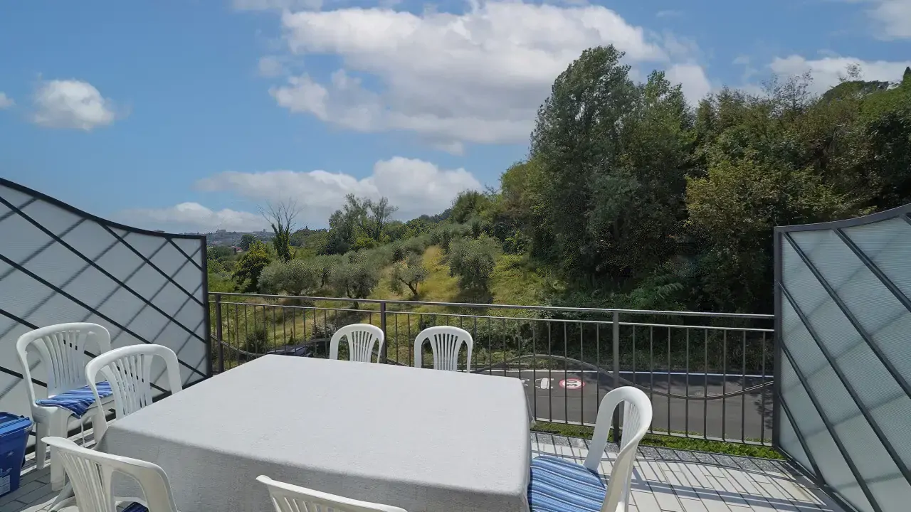Terrace with table and white chairs with blue cushions