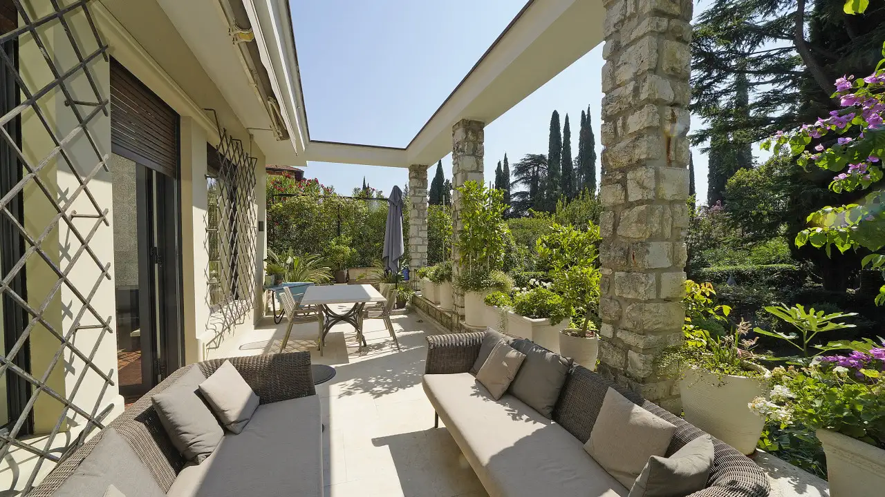 Terrazza con divani e tavolo all'aperto con piante in vaso