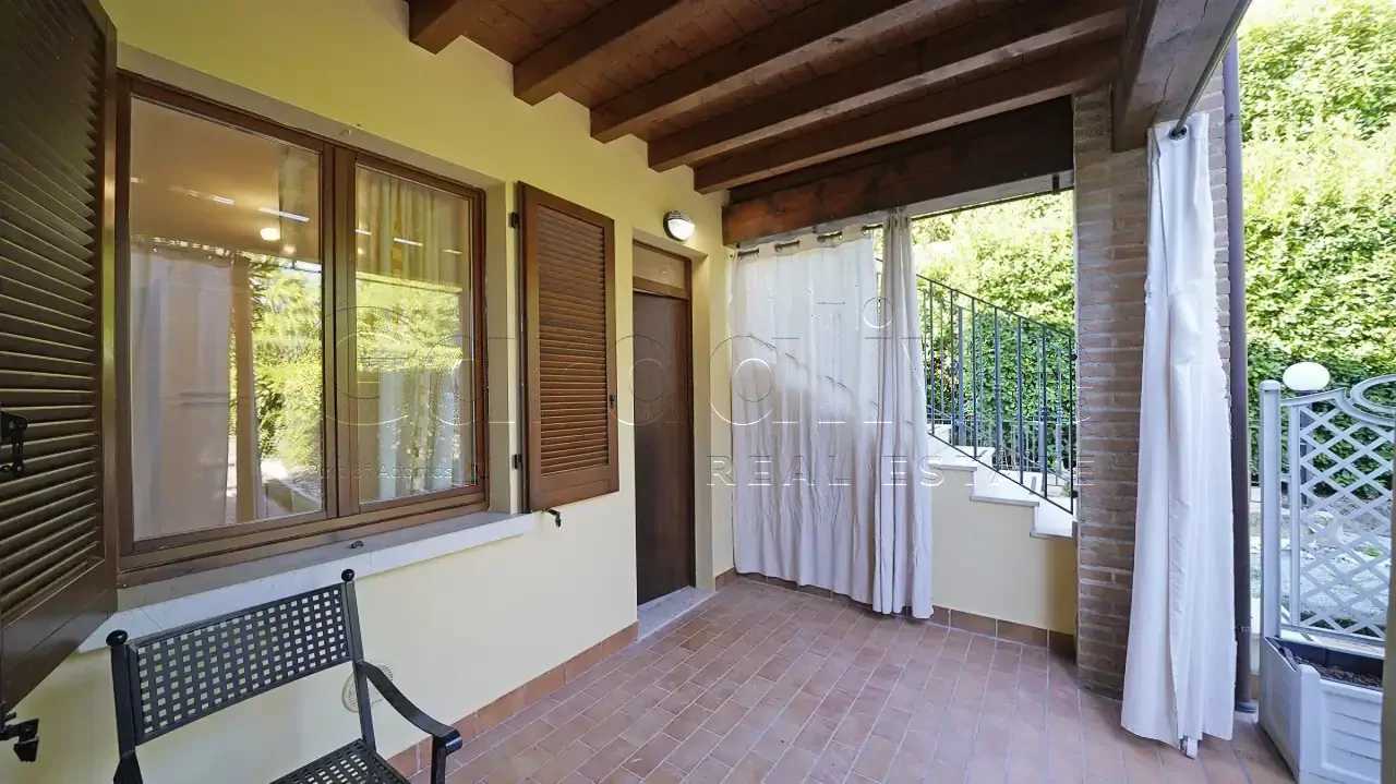 Veranda mit Terrakottaboden und sichtbaren Holzbalken
