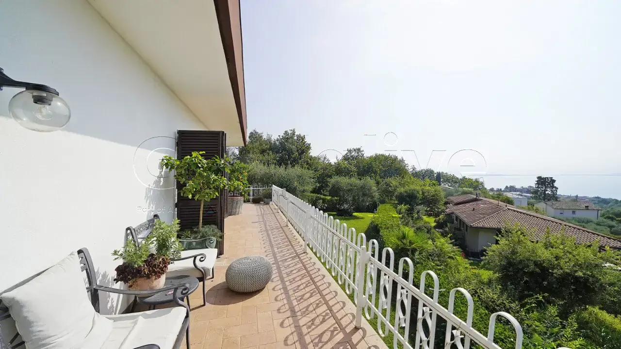 Terrazza con sedie e vista sul giardino e lago