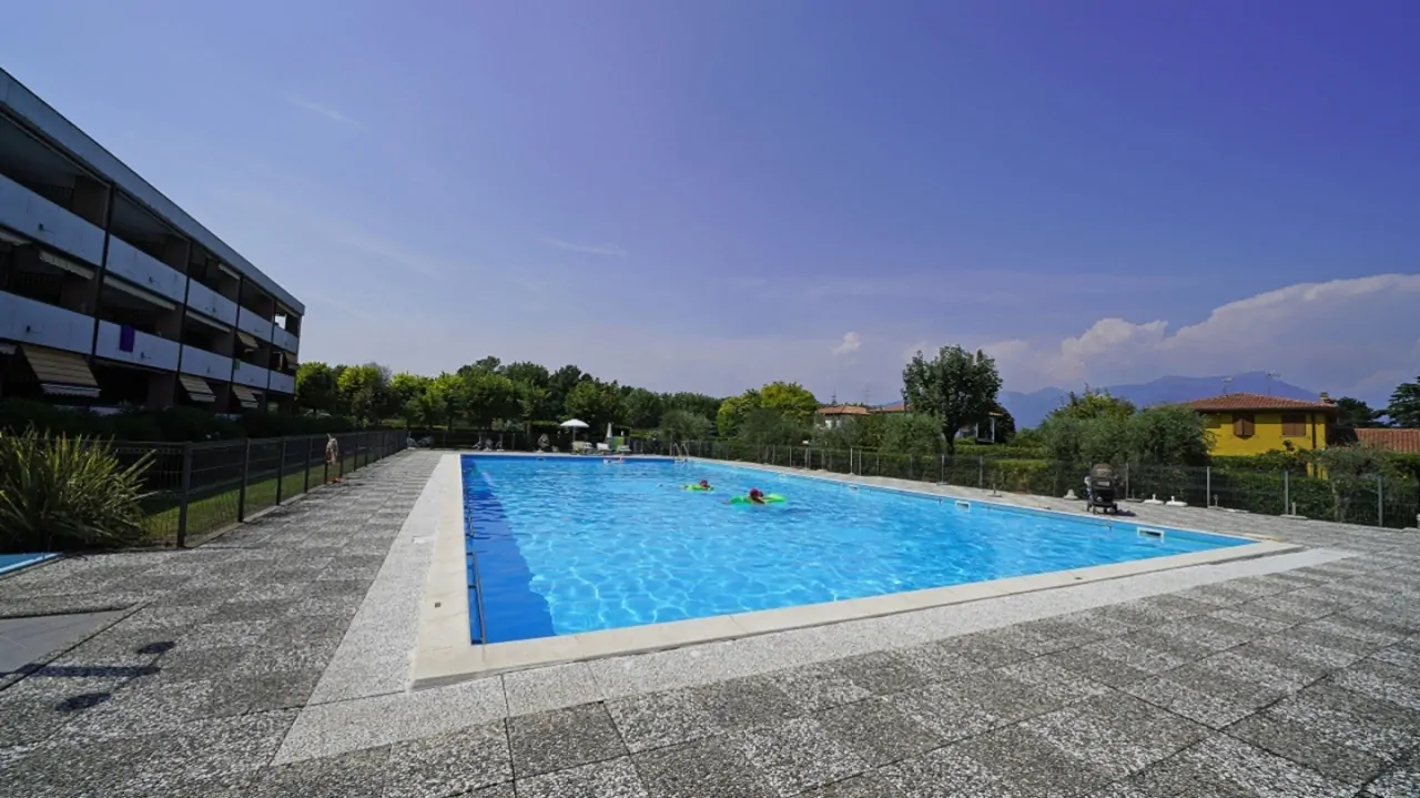 Piscina all'aperto con bordo in pietra e recinzione