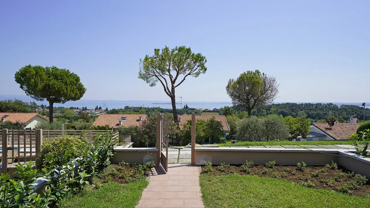 Giardino con prato, aiuole e vista sul lago