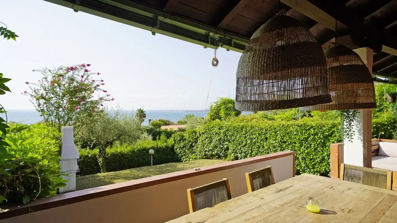Terrace with wooden table and view of garden and lake
