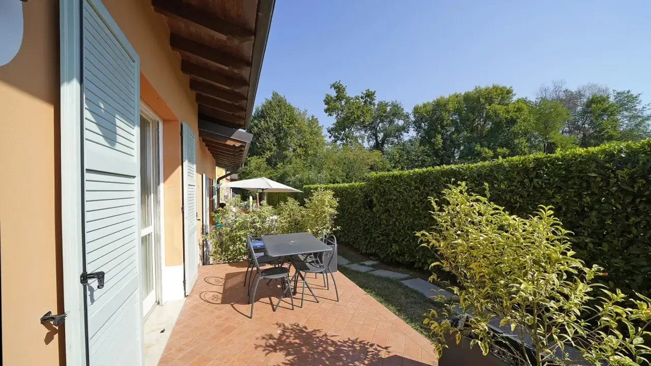 Terrasse mit Tisch, Stühlen und grünem Hecken