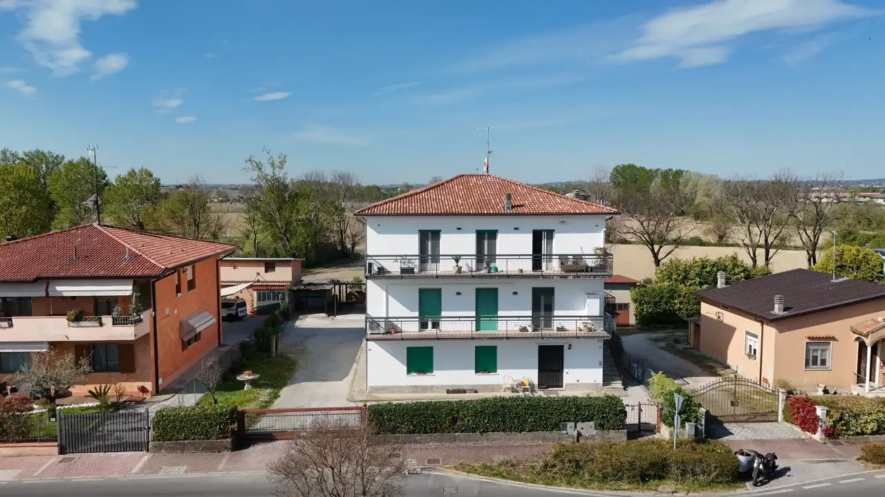 Palazzina bianca con balconi e tetto rosso vista da drone