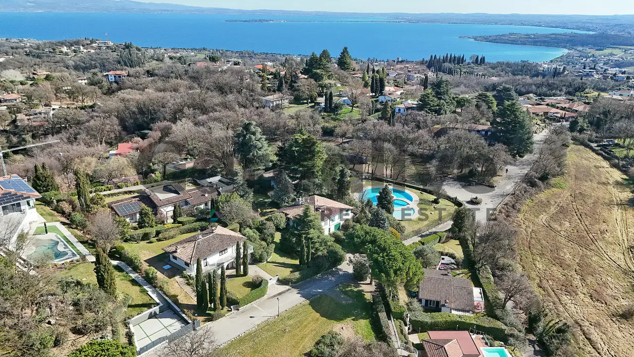Aerial view of semi-detached villa with garden and lake in the background
